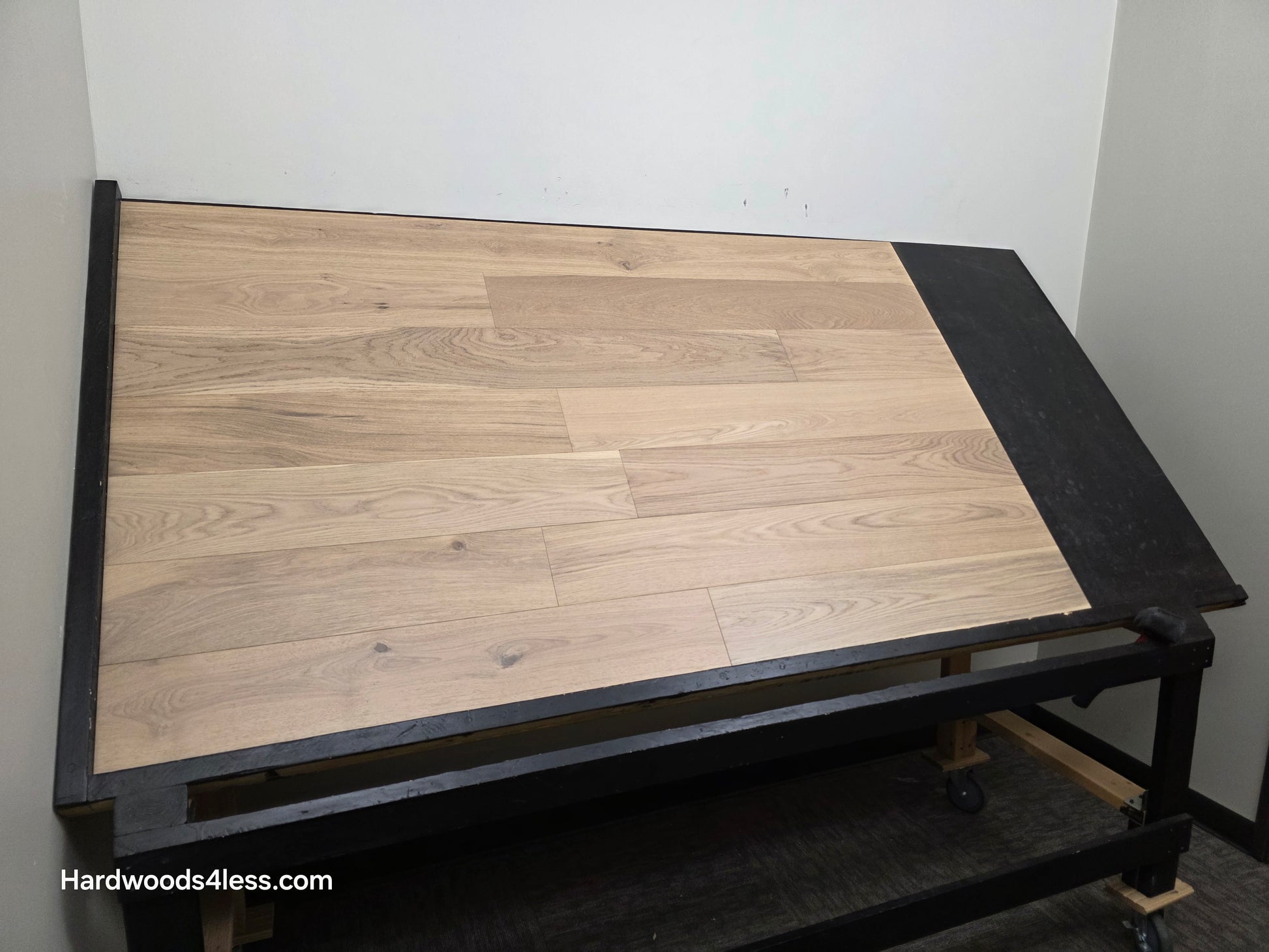 6 1/2" x 1/2" Engineered European White Oak Mojito Hardwood Flooring. Shown on a black shooting table. Shot from wide left.