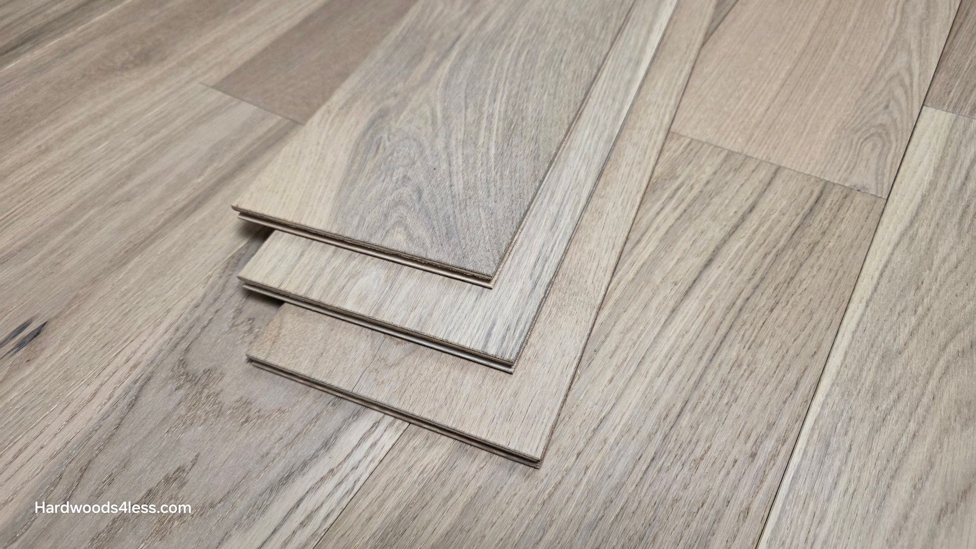 6 1/2" x 1/2" Engineered European White Oak Mojito Hardwood Flooring. Show as three tiles stacked atop the floor. 