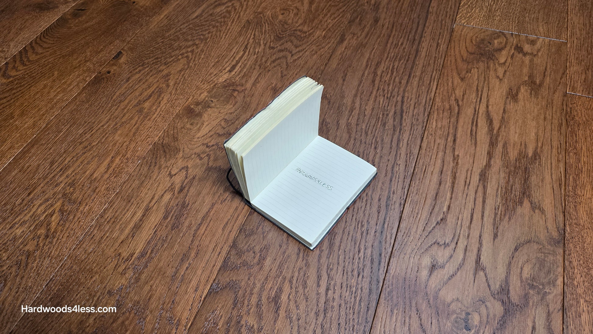6 1/2" x 1/2" Engineered European White Oak Old Fashioned Hardwood Flooring. Shown with a small book, with the words, Hardwoods4less, Written in the center. 