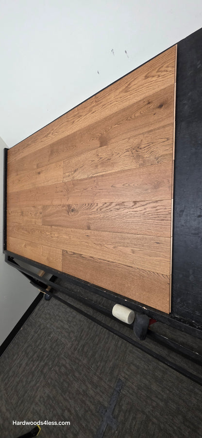 6 1/2" x 1/2" Engineered European White Oak Tequila Sunrise Hardwood Flooring. Shown on a black shooting table. Shot from steep right.