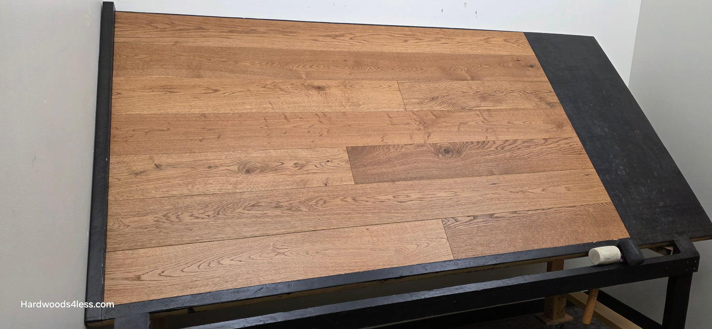 6 1/2" x 1/2" Engineered European White Oak Tequila Sunrise Hardwood Flooring. Shown on a black shooting table. Shot from wide left.