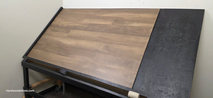 6 1/2" x 1/2" Engineered Maple Peat Hardwood Flooring. Shown on a black shooting table. Shot from wide right.