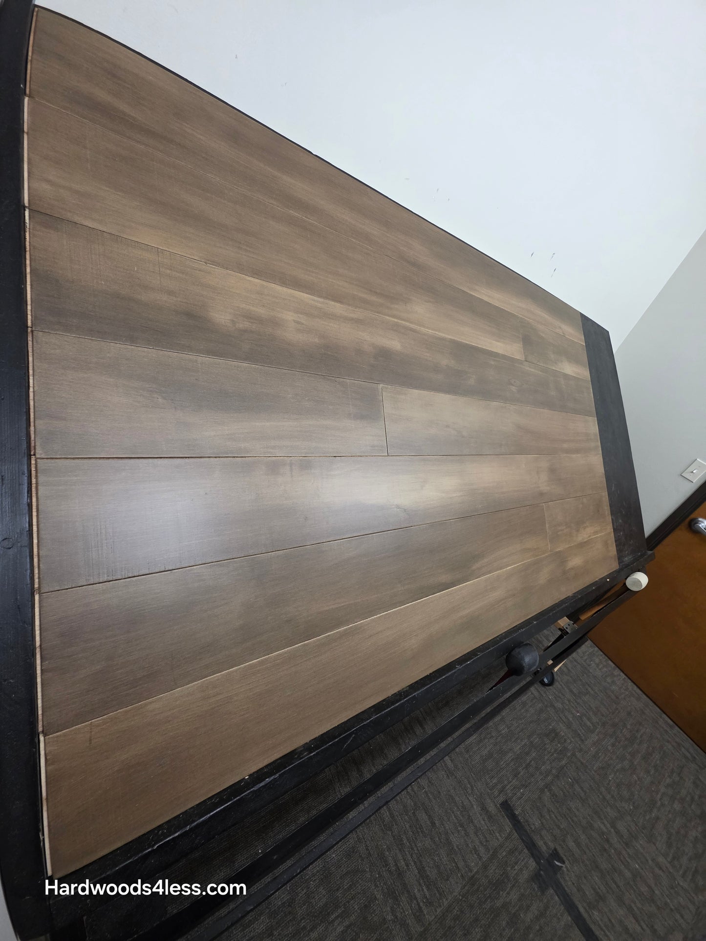 6 1/2" x 1/2" Engineered Maple Peat Hardwood Flooring. Shown on a black shooting table. Shot from steep left. 