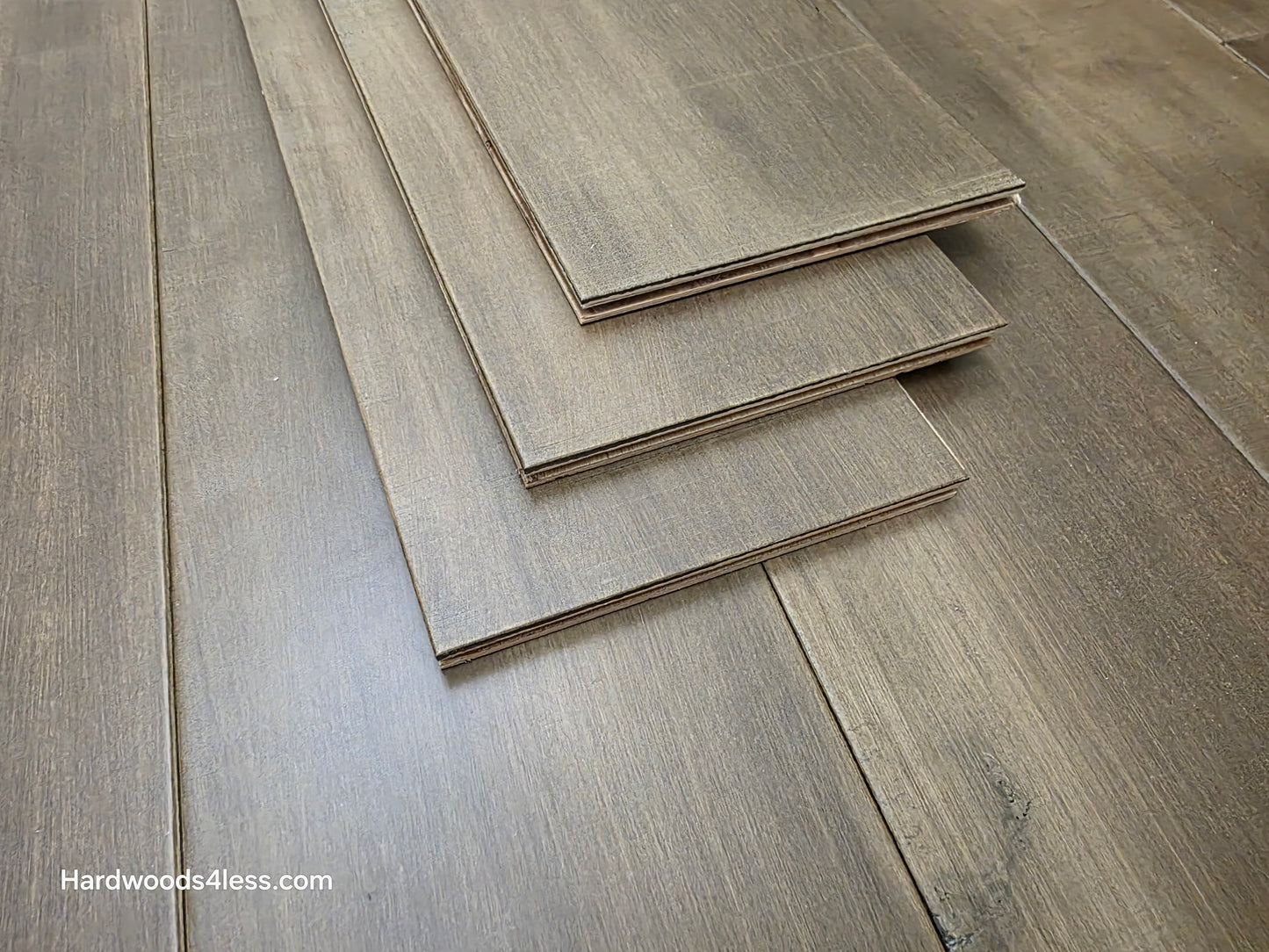 6 1/2" x 1/2" Engineered Maple Peat Hardwood Flooring. Shown as 3 planks stacked on top of the flooring. Shot close up.