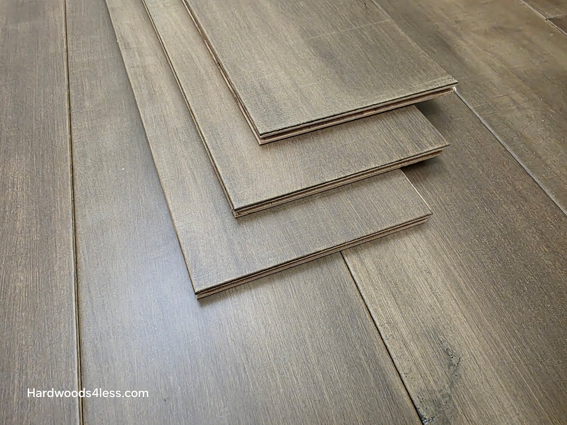 6 1/2" x 1/2" Engineered Maple Peat Hardwood Flooring. Shown as 3 planks stacked on top of the flooring. Shot close up.