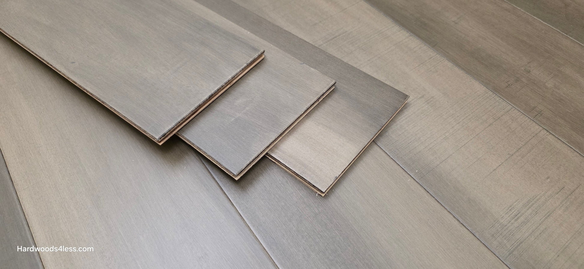 6 1/2" x 1/2" Engineered Maple Weathered Winter Hardwood Flooring. Shown with three extra boards stacked in the center of the frame.