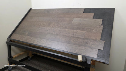 6 1/2" x 3/8" Engineered White Oak Nocturne Hardwood Flooring. Shown on a black shooting table. Shot from wide right.