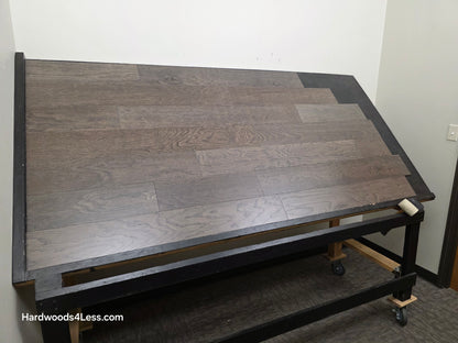 6 1/2" x 3/8" Engineered White Oak Nocturne Hardwood Flooring. Shown on a black shooting table. Shot from wide right.