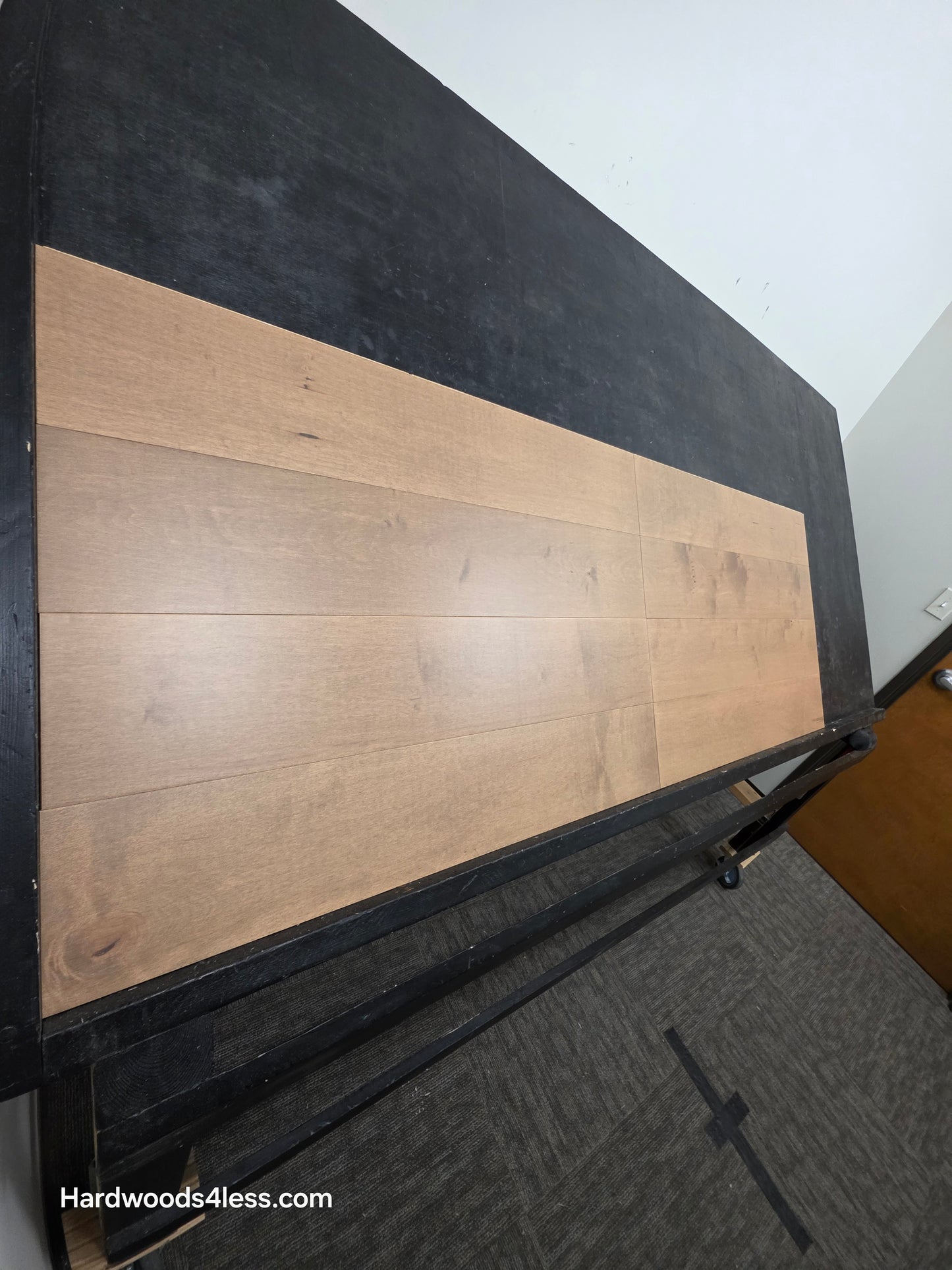 6 1/2" x 5/8" Engineered Maple Sandy Beach Hardwood Flooring. Shown on a black shooting table. Shot from steep left. 