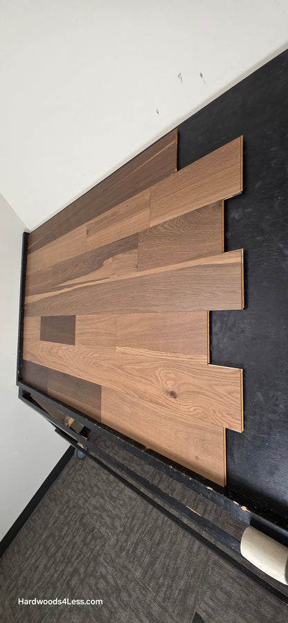 6 1/2" x 7/16" Engineered White Oak Wingham Hardwood Flooring. Shown on a black shooting table. Shot from steep right.