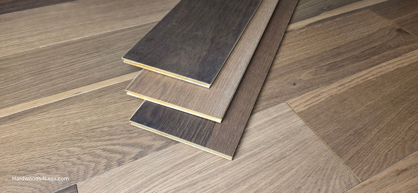 6 1/2" x 7/16" Engineered White Oak Wingham Hardwood Flooring. Shown in the center are 3 planks of the Engineered White Oak flooring. Under the planks is the same hardwood flooring.