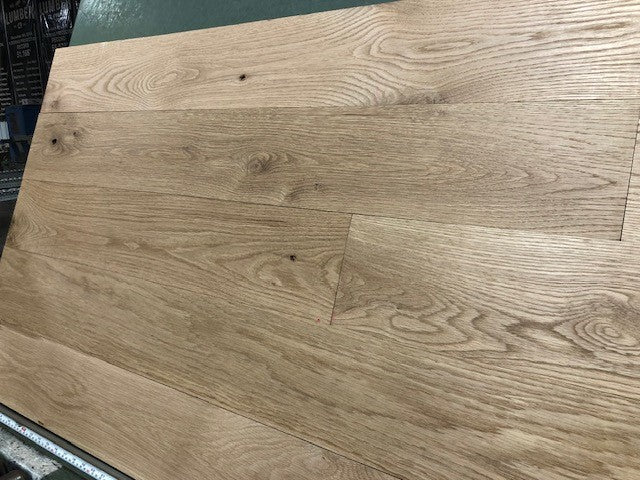6" x 3/4" Unfinished White Oak #1 Common Solid Hardwood Flooring on a green shooting rack.