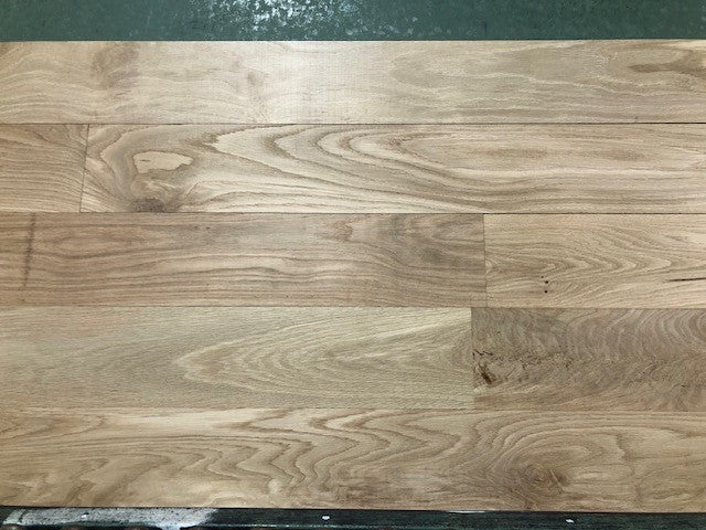 6" x 3/4" Unfinished White Oak #1 Common Solid Hardwood Flooring on a green shooting rack.
