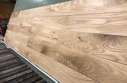 6" x 3/4" Unfinished White Oak #1 Common Solid Hardwood Flooring on a green shooting rack.