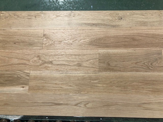 6" x 3/4" Unfinished White Oak #1 Common Solid Hardwood Flooring on a green shooting rack.