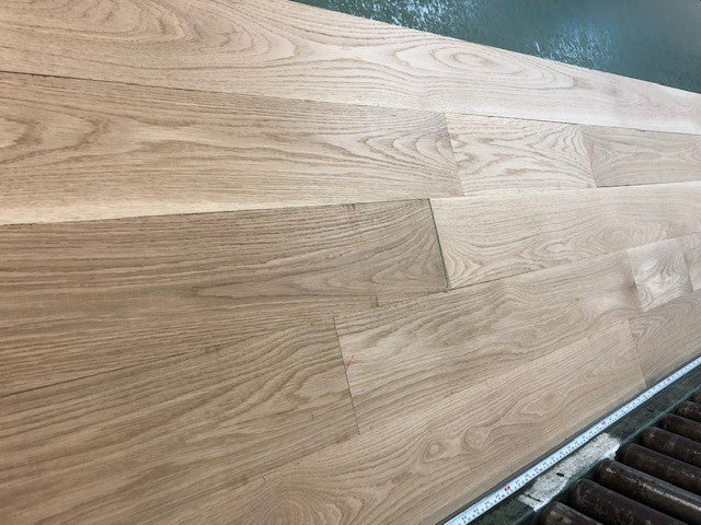 6" x 3/4" Unfinished White Oak Select & Better Solid Hardwood Flooring shown on a green shooting table 