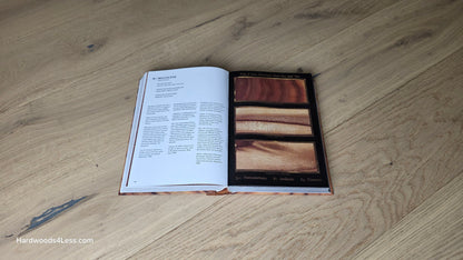 7 1/2" x 1/2" Engineered European White Oak Belleray Hardwood Flooring. Shown with a hardwood book. Sitting in the center on top of the Engineered White oak flooring.