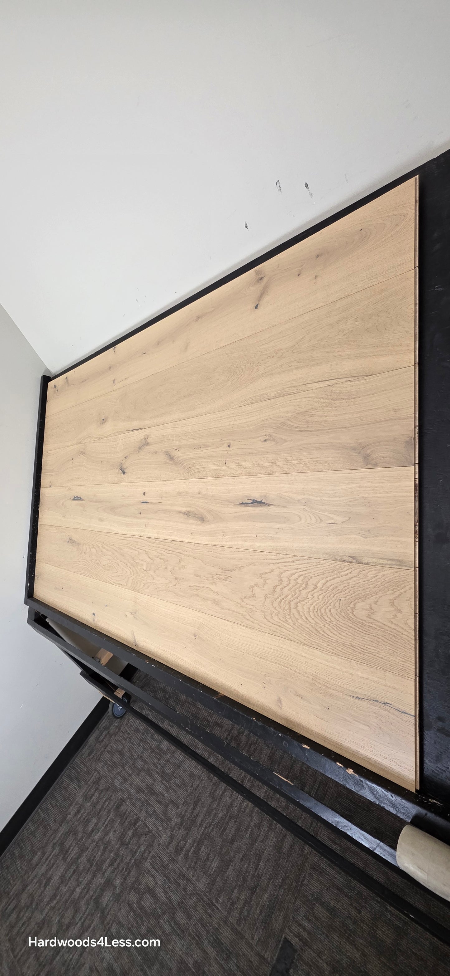 7 1/2" x 1/2" Engineered European White Oak Belleray Hardwood Flooring. Shown on a black shooting table. Shot from steep right.