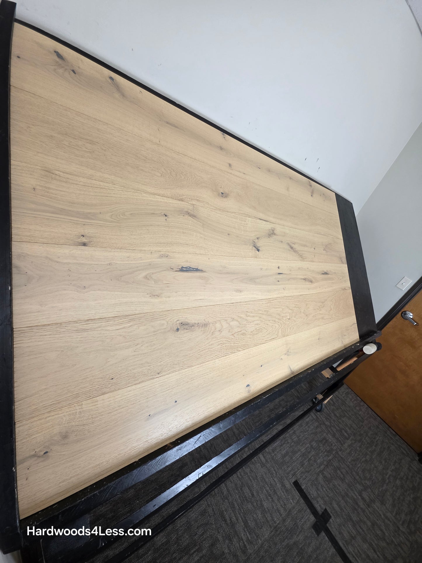7 1/2" x 1/2" Engineered European White Oak Belleray Hardwood Flooring. Shown on a black shooting table. Shot from steep left. 