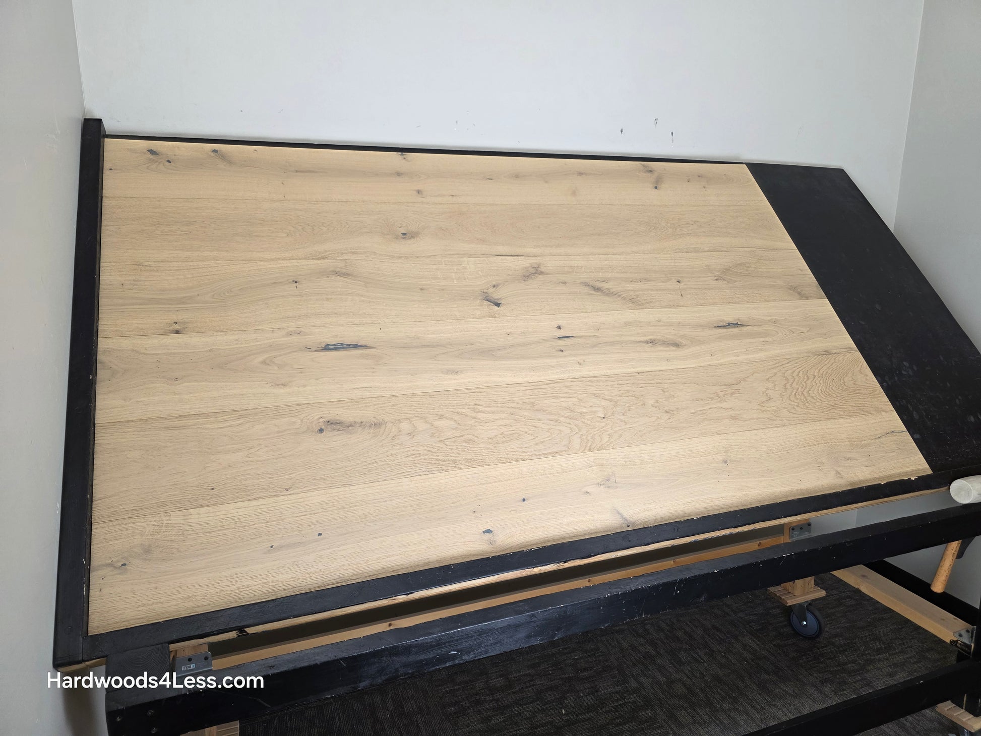 7 1/2" x 1/2" Engineered European White Oak Belleray Hardwood Flooring. Shown on a black shooting table. Shot from wide left. 