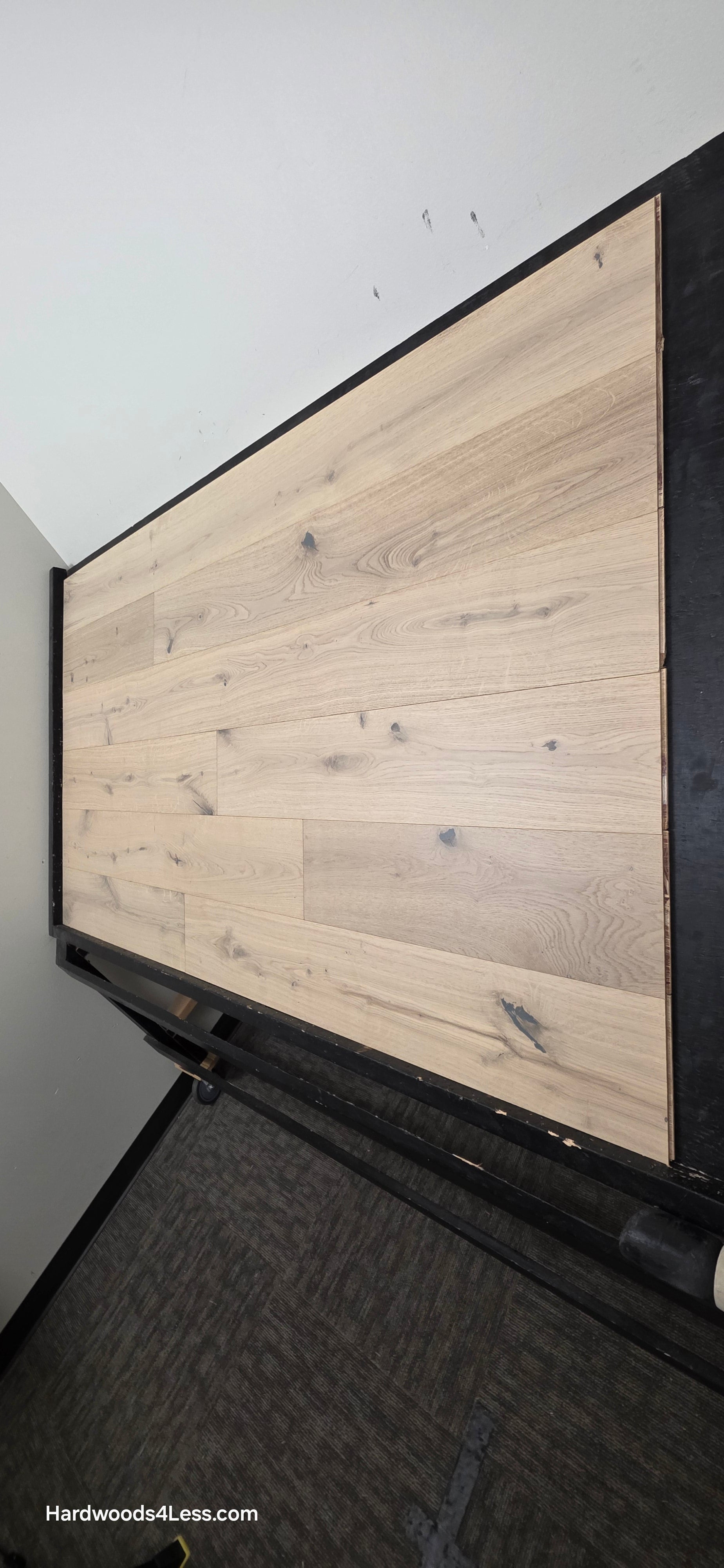 7 1/2" x 1/2" Engineered European White Oak Colmar Hardwood Flooring. Shown on a black shooting table. Shot from steep right.