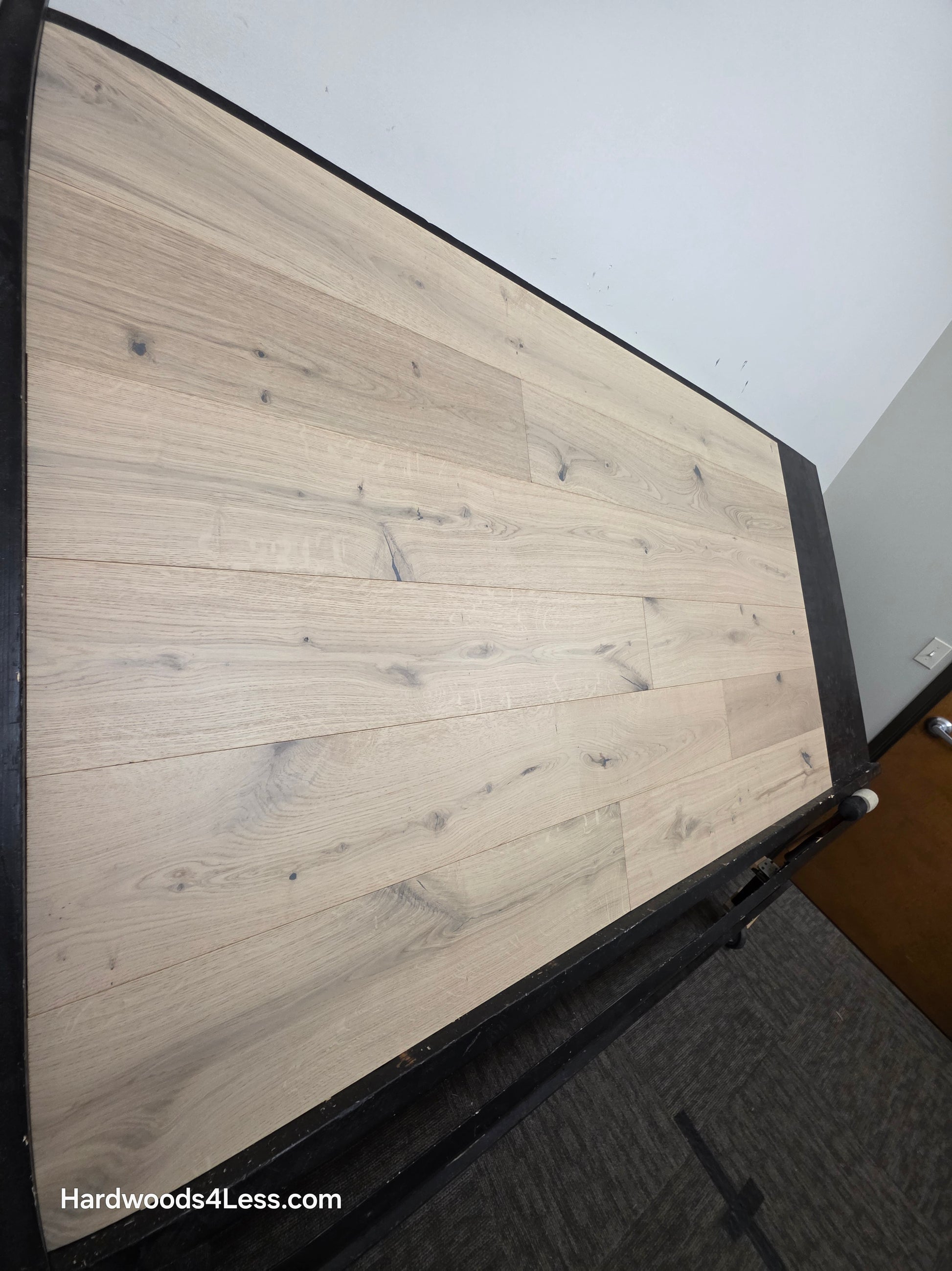 7 1/2" x 1/2" Engineered European White Oak Colmar Hardwood Flooring. Shown on a black shooting table. Shot from steep left. 
