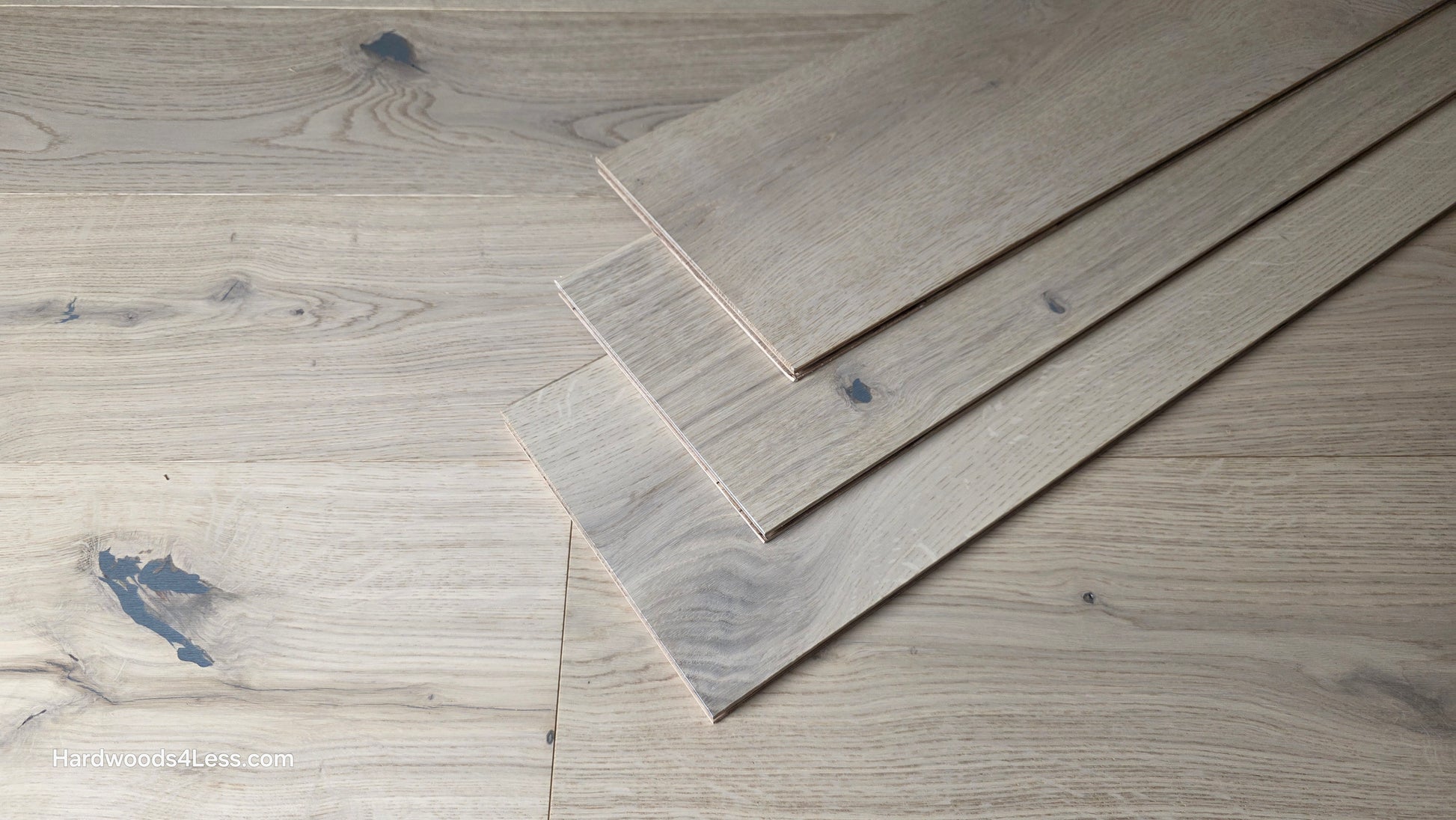 7 1/2" x 1/2" Engineered European White Oak Colmar Hardwood Flooring. Shown as 3 planks resting on top of each other. These are sitting center frame on top of the Engineered White Oak flooring.