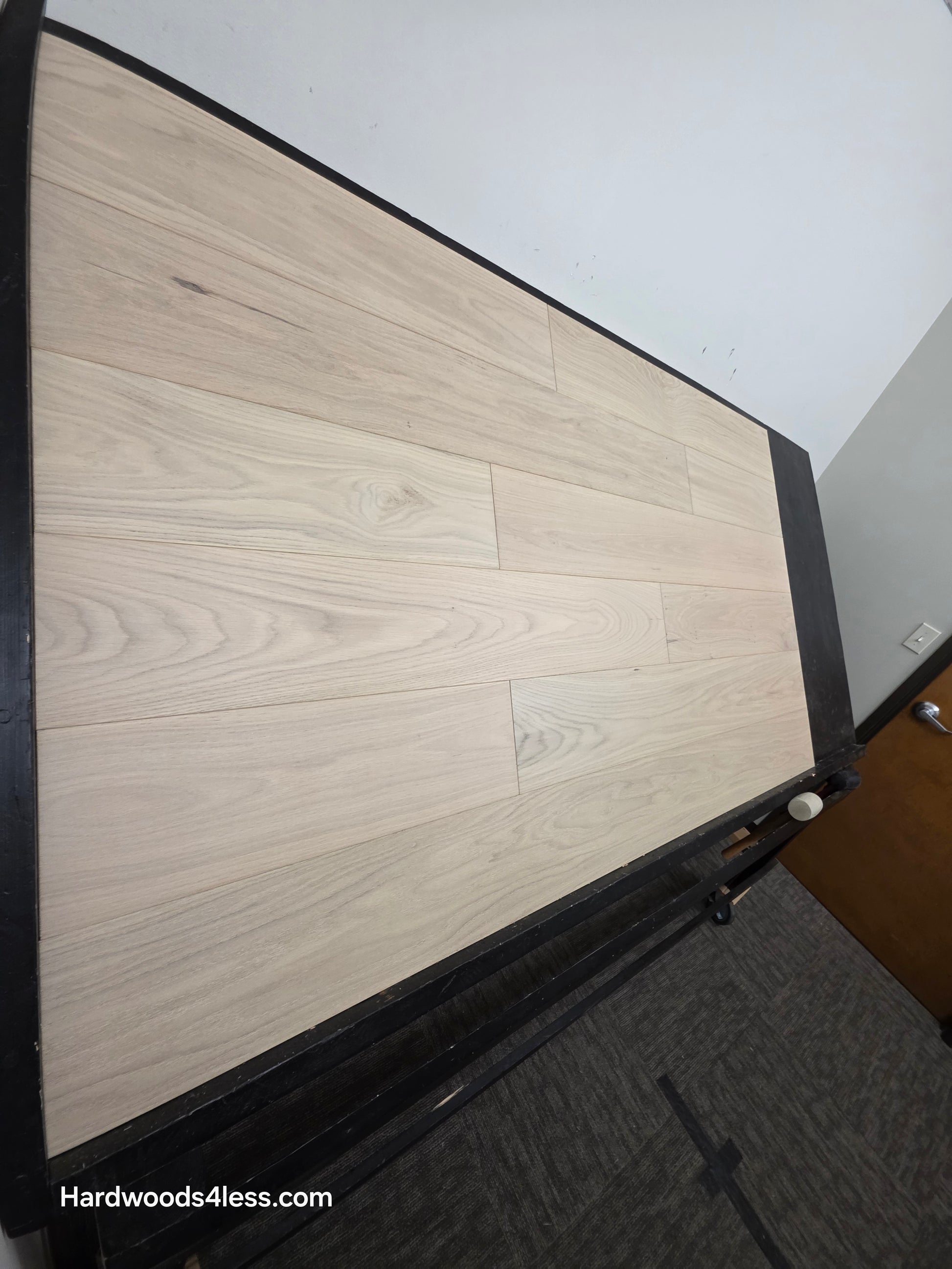 7 1/2" x 1/2" Engineered European White Oak Florence Hardwood Flooring. Shown on a black shooting table. Shot from steep left. 