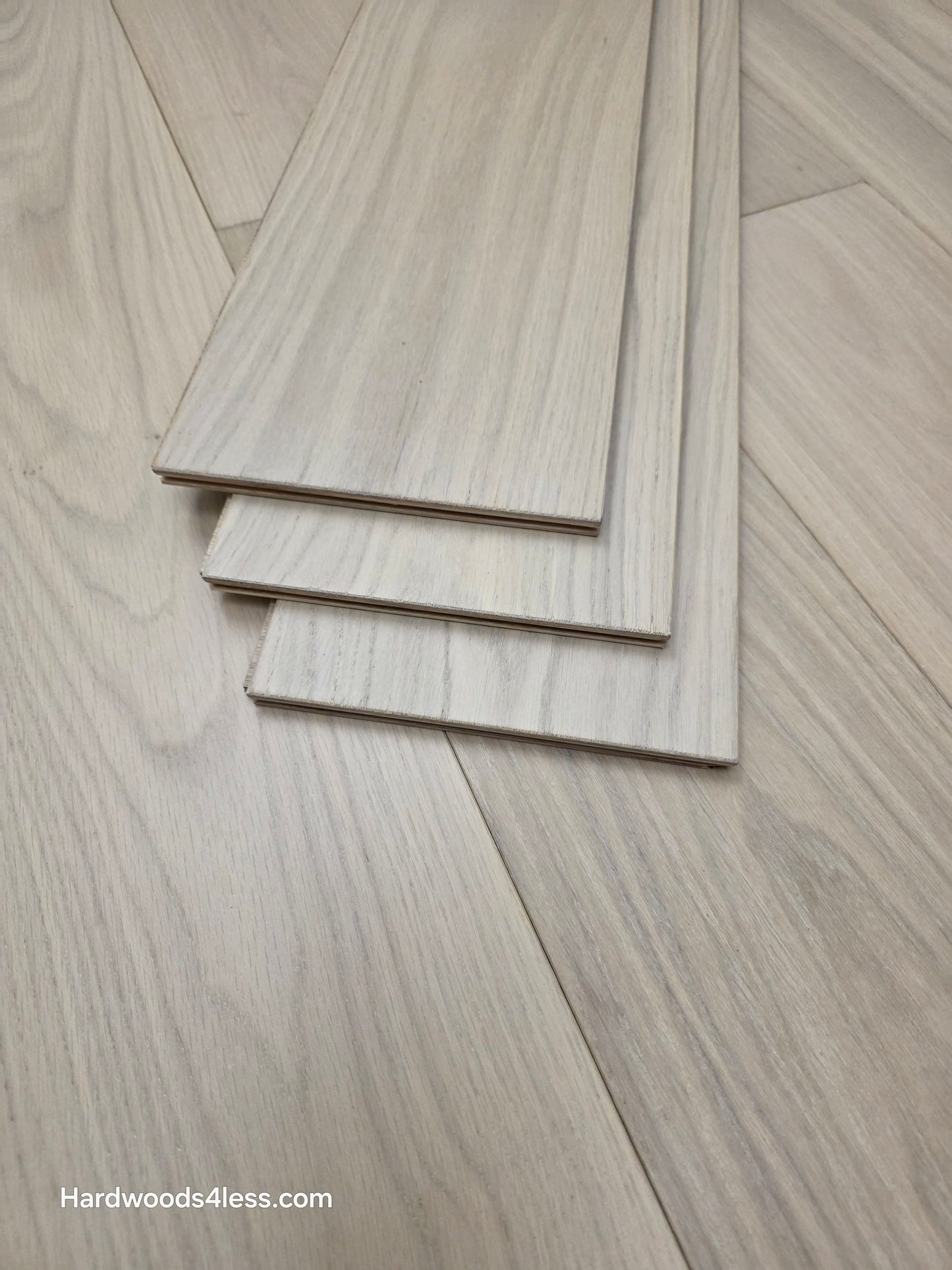 7 1/2" x 1/2" Engineered European White Oak Florence Hardwood Flooring. Shown as three tiles stacked atop the flooring.