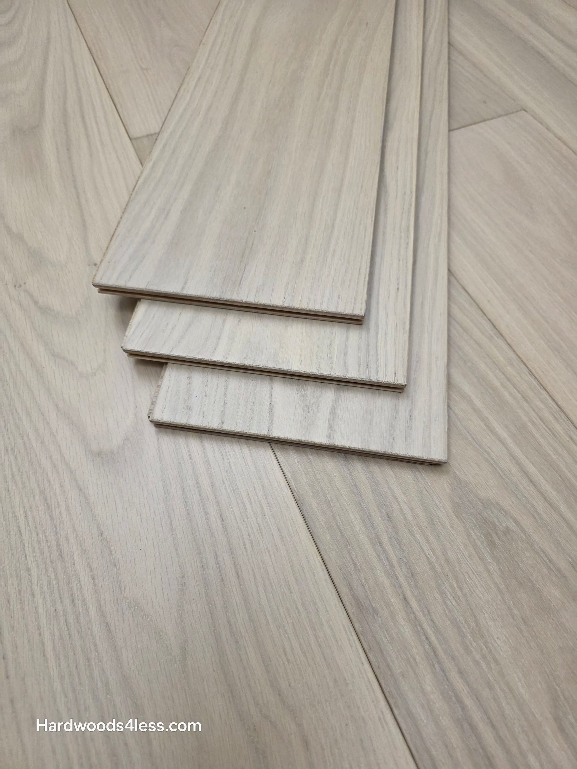 7 1/2" x 1/2" Engineered European White Oak Florence Hardwood Flooring. Shown as three tiles stacked atop the flooring.