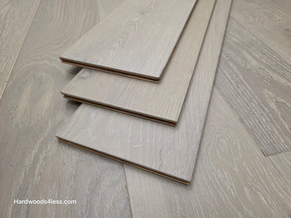 7 1/2" x 9/16" Engineered European Oak Alderney Hardwood Flooring. Shown with three boards stacked in the center of the floor.