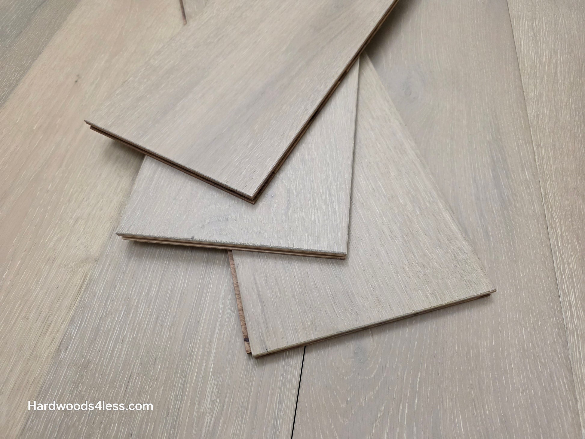7 1/2" x 9/16" Engineered European Oak Sark Hardwood Flooring shown with three planks stacked in the center of the floor. 