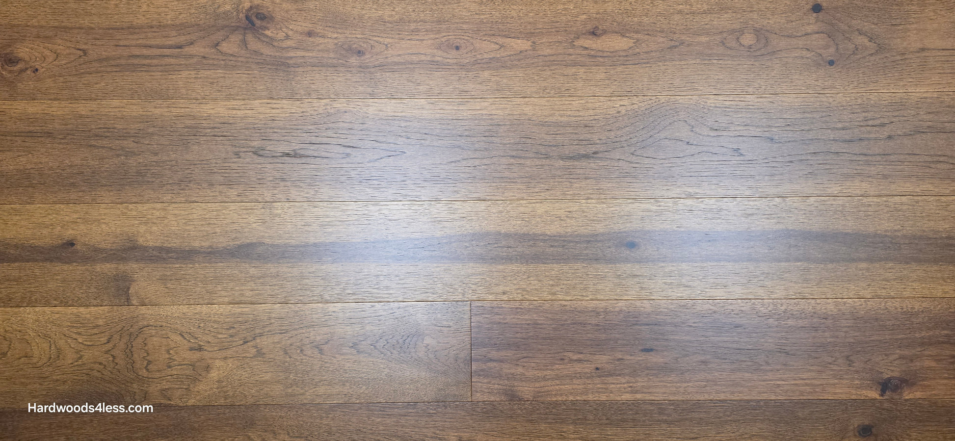 Close-up of 7 1/2" x 9/16" Engineered Hickory Alabay Hardwood Flooring with a visible brand name 'Hardwoods4less.com'.