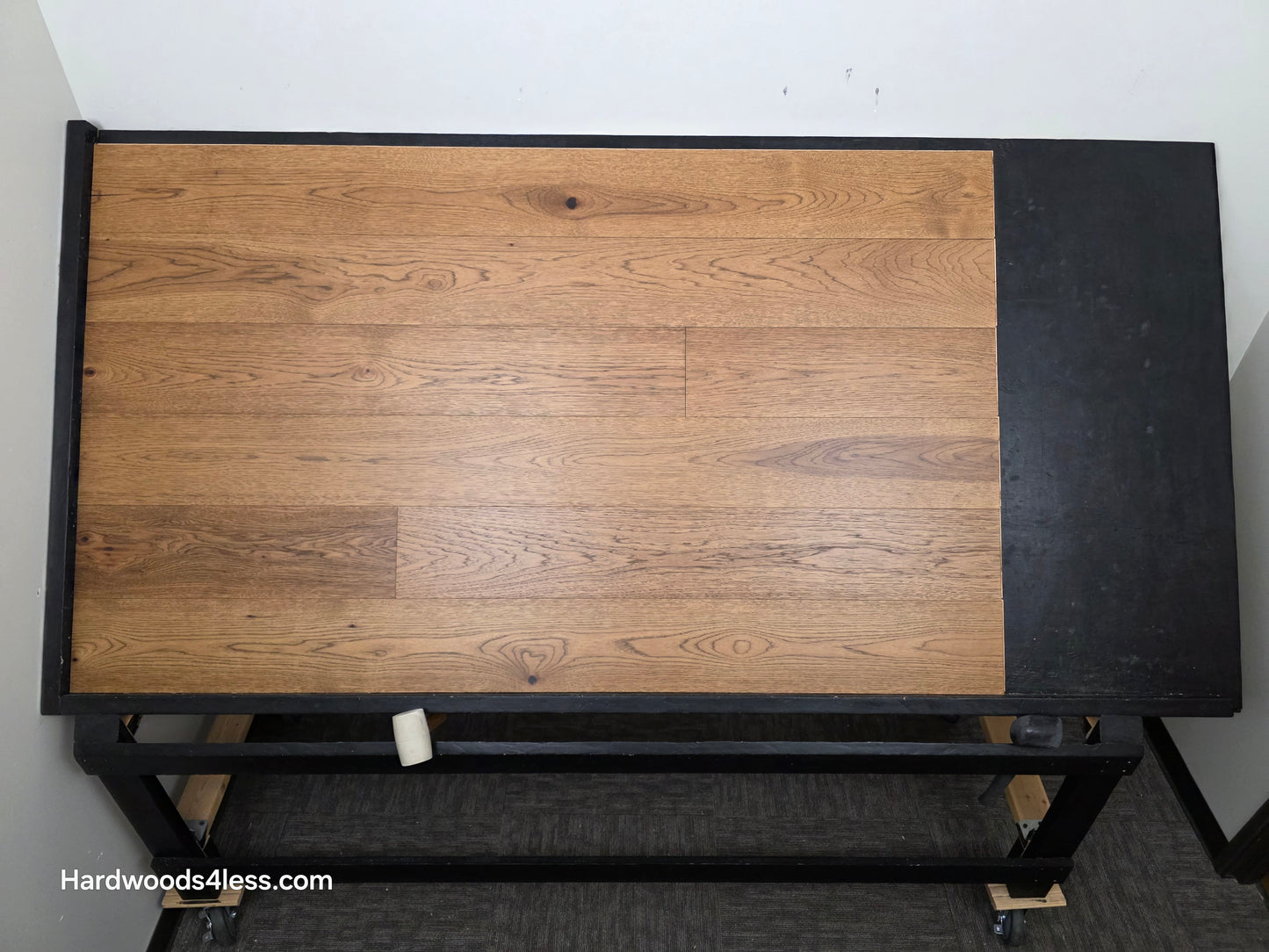 7 1/2" x 9/16" Engineered Hickory English Toffee Hardwood Flooring. Shown on a black shooting table. Shot from center. 