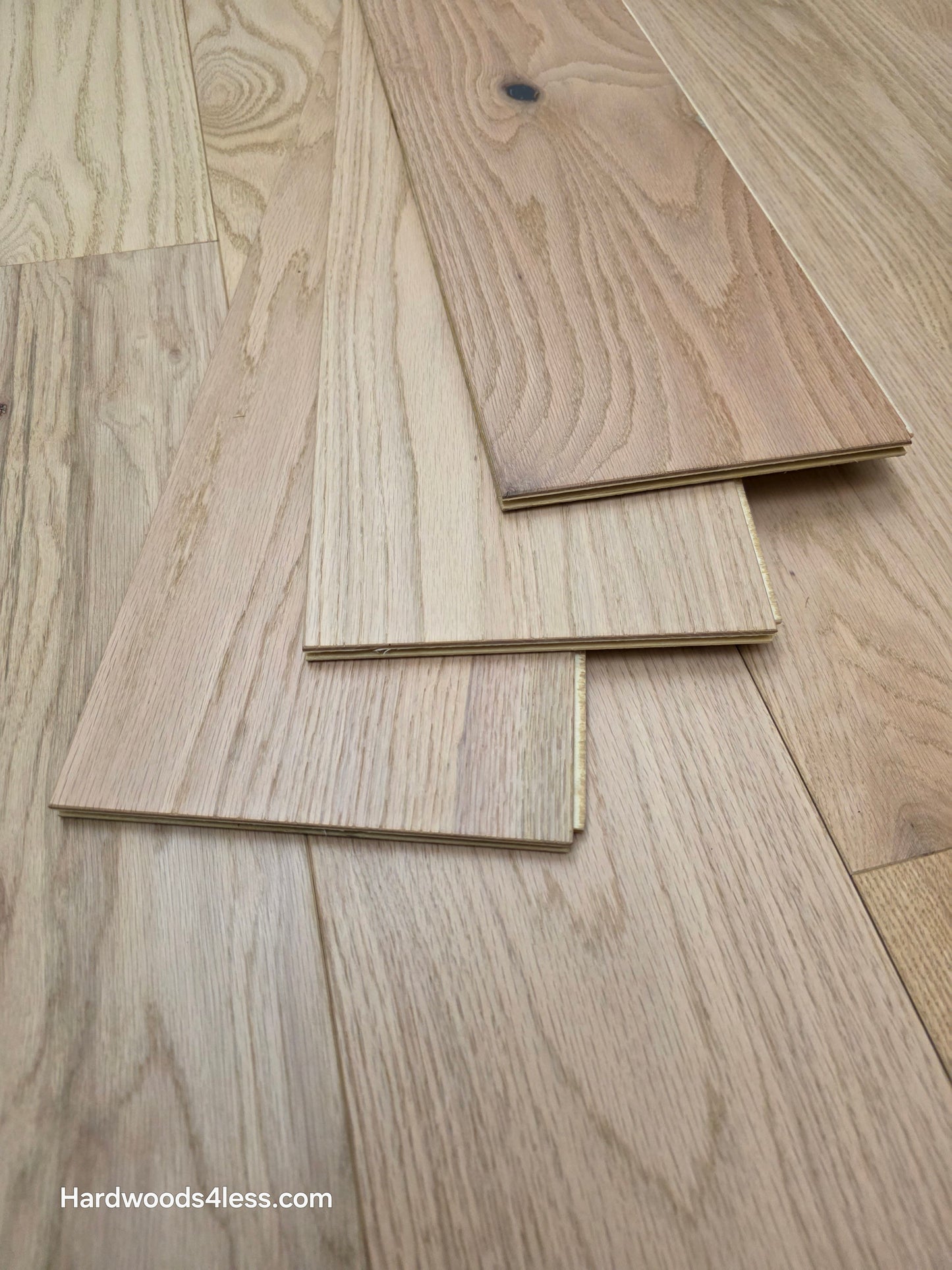 7 3/8" x 1/2" Engineered Red Oak San Bernard Hardwood Flooring. Shown as 3 boards stacked atop one another on the floor. 