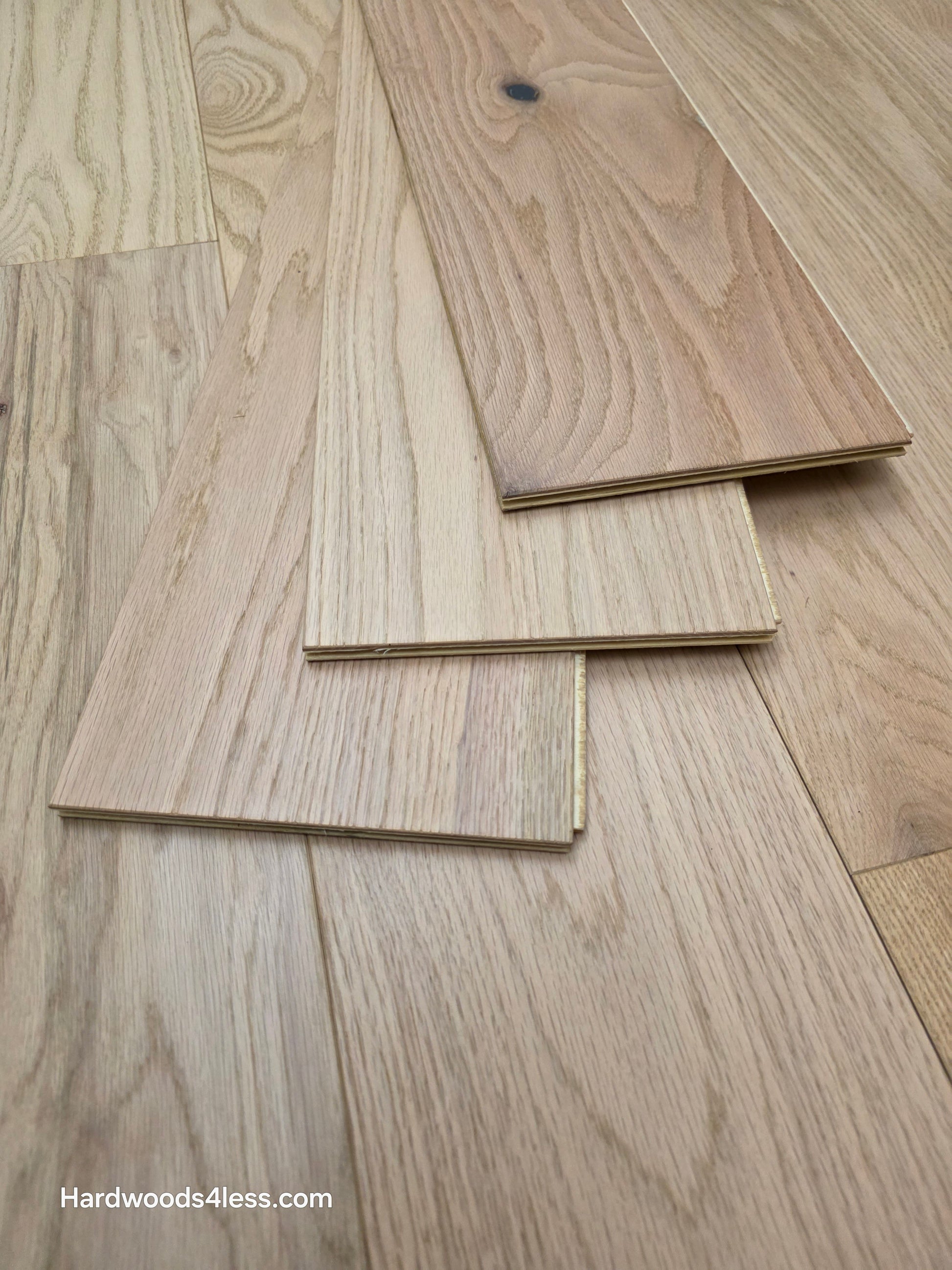 7 3/8" x 1/2" Engineered Red Oak San Bernard Hardwood Flooring. Shown as 3 boards stacked atop one another on the floor. 