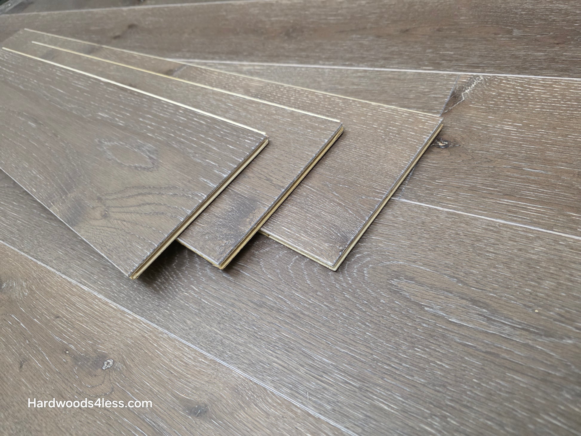 7 3/8" x 1/2" Engineered White Oak Sedona Hardwood Flooring. Shown as three tiles stacked on top of the floor. 