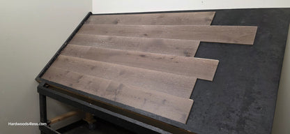 7 3/8" x 1/2" Engineered White Oak Sedona Hardwood Flooring. Shown on a  black shooting table. Wide right hand shot.