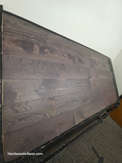 7 3/8" x 5/8" Engineered White Oak Toasted Cocoa Hardwood Flooring. Shown on a black shooting table, steep left side shot.