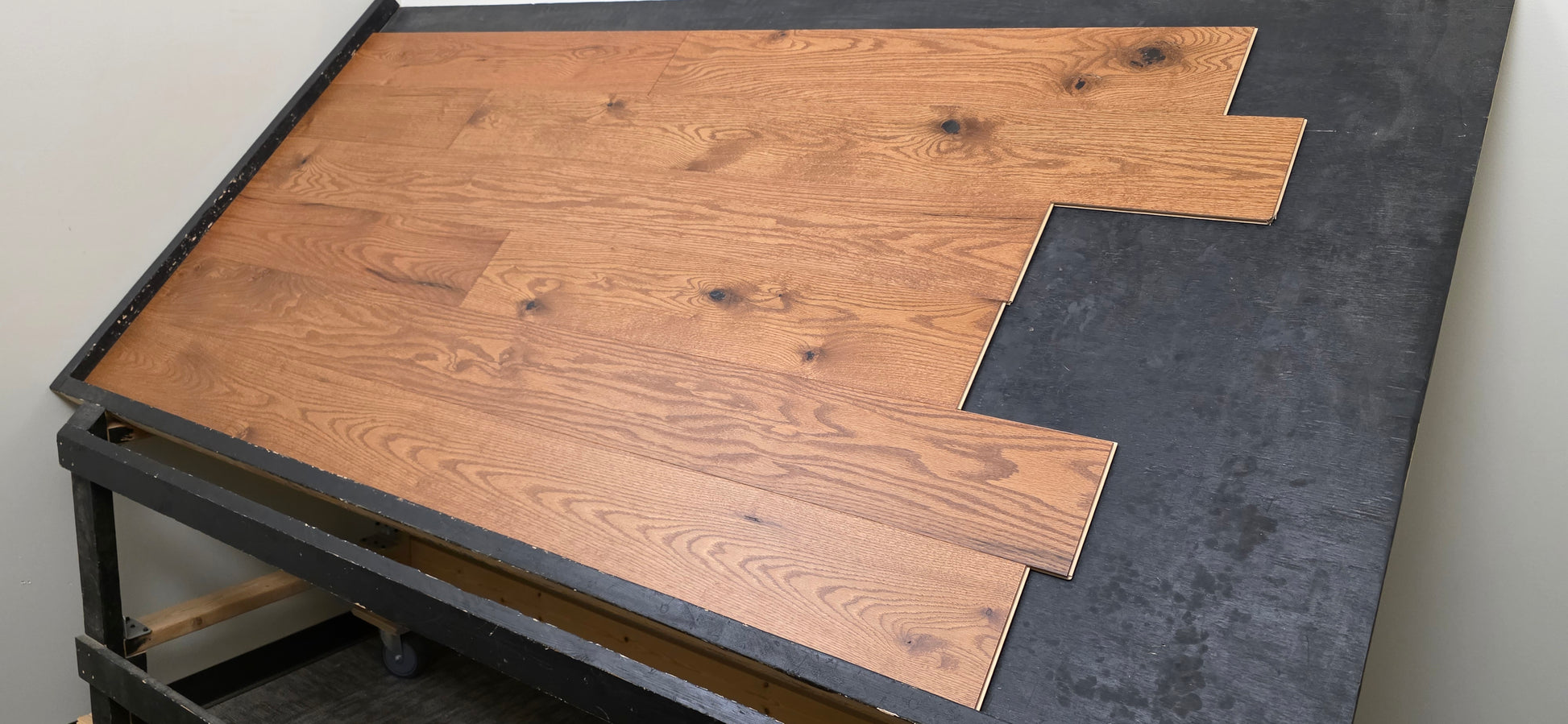 Engineered Red Oak Gunstock Hardwood Flooring on a black table wide shot right side