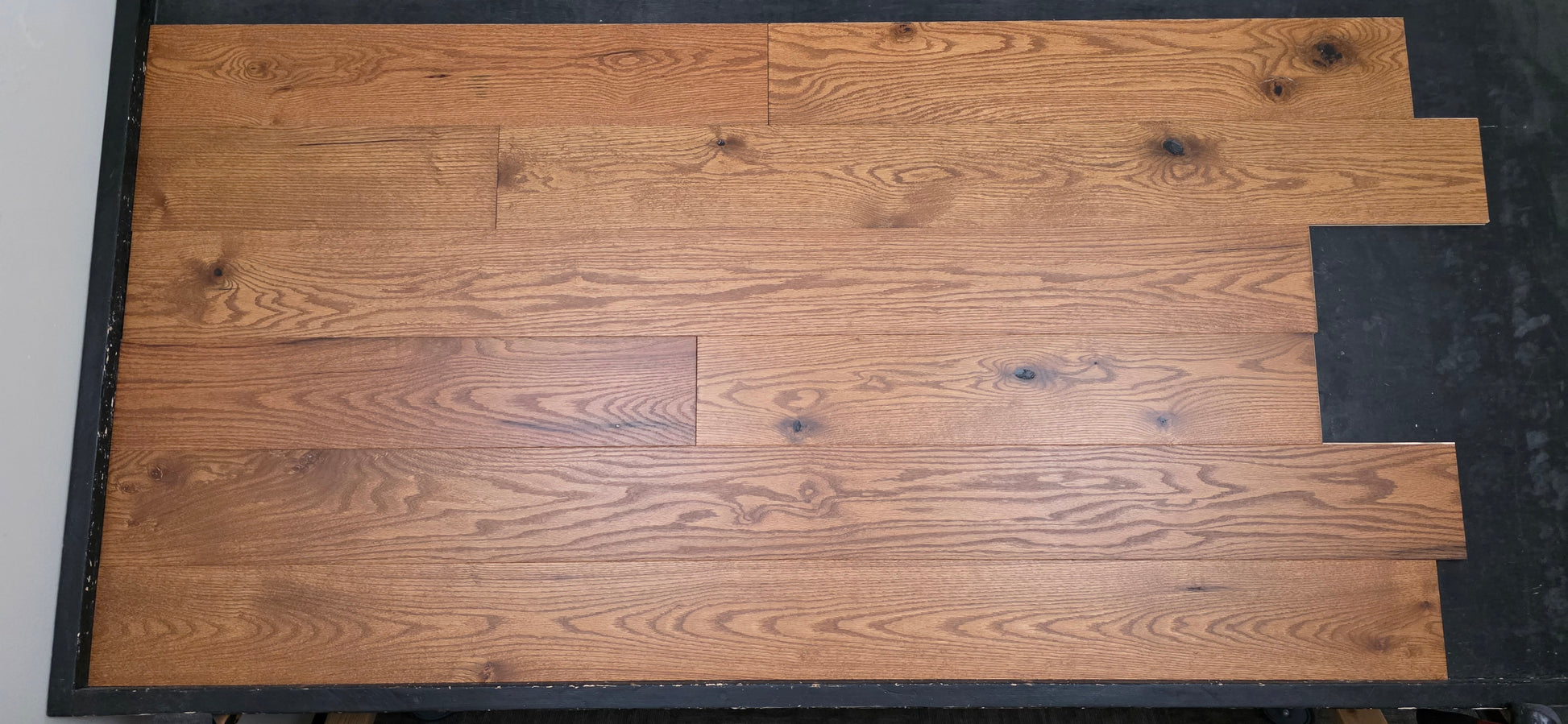 Engineered Red Oak Gunstock Hardwood Flooring on a black table head on