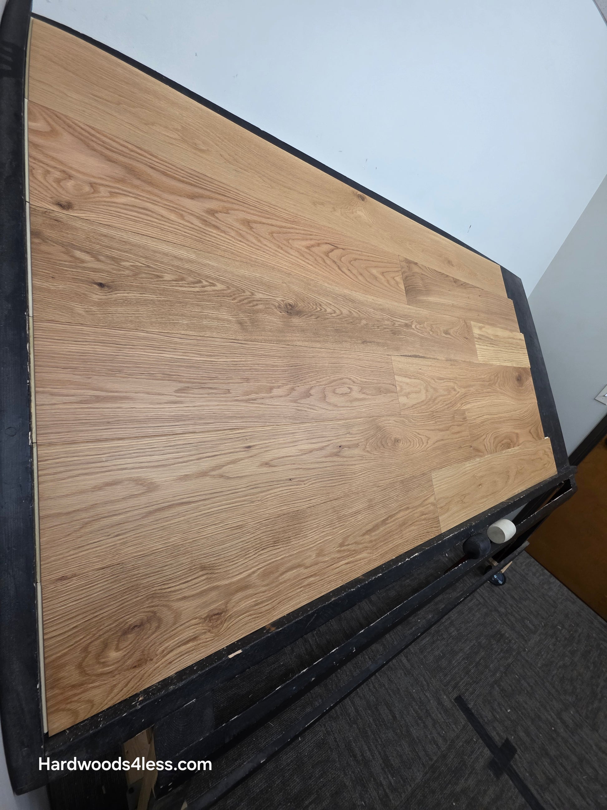 7" x 1/2" Engineered White Oak Natural Hardwood Flooring. Shown on a black shooting table. Shot from steep left.