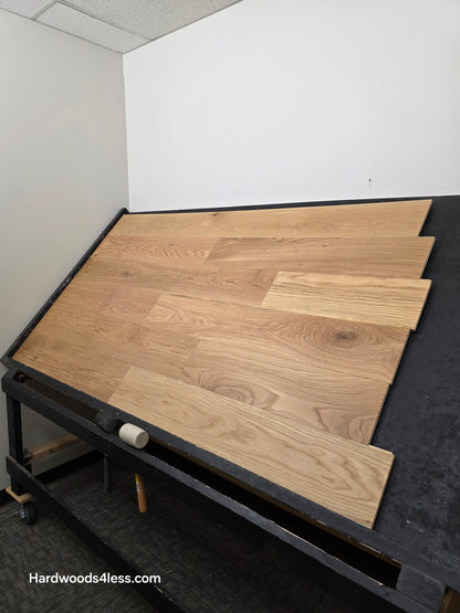 7" x 1/2" Engineered White Oak Natural Hardwood Flooring. Shown on a black shooting table. Shot from steep right.