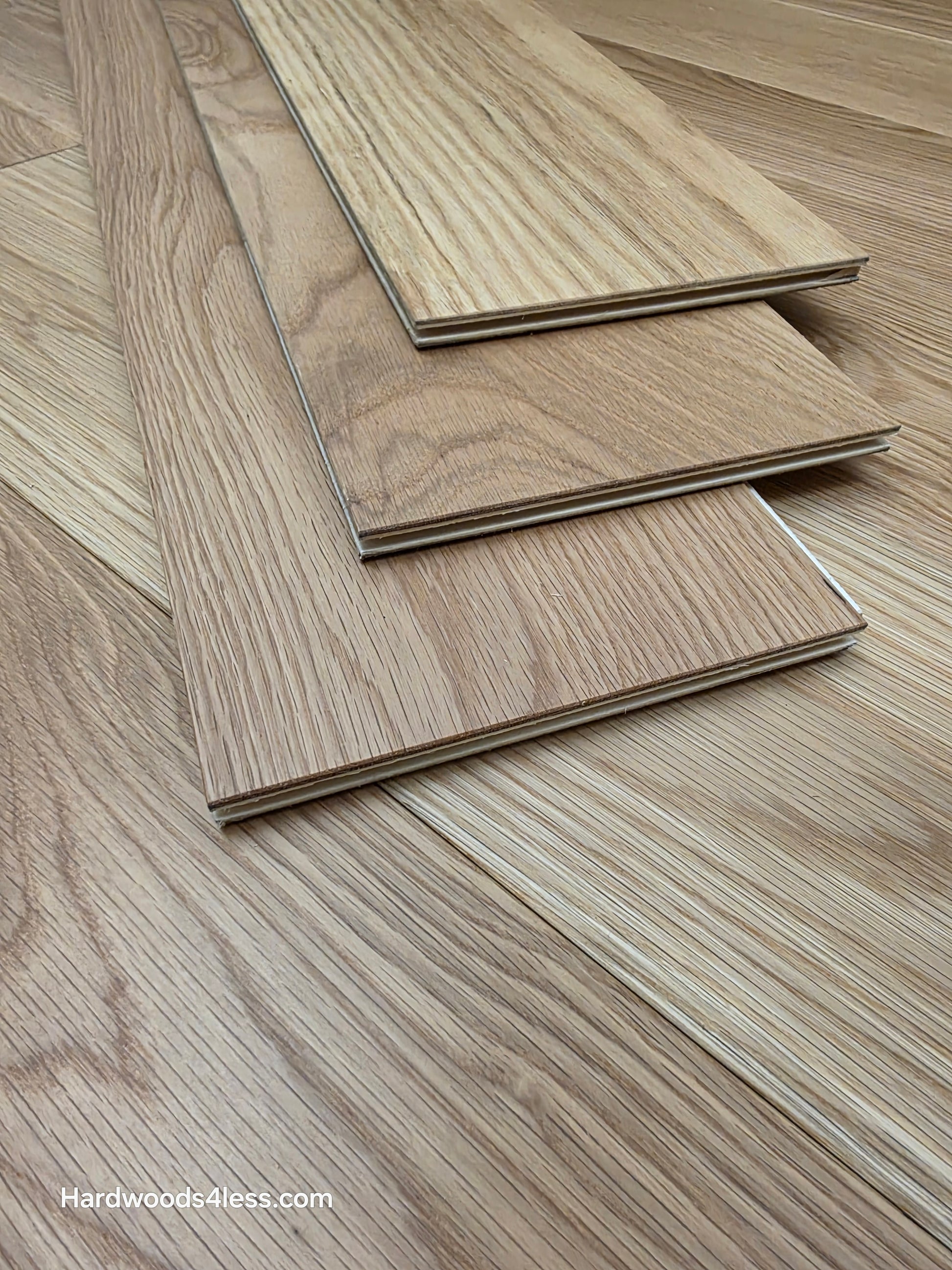 7" x 1/2" Engineered White Oak Natural Hardwood Flooring. Shown as three boards stacked on top of the floor.