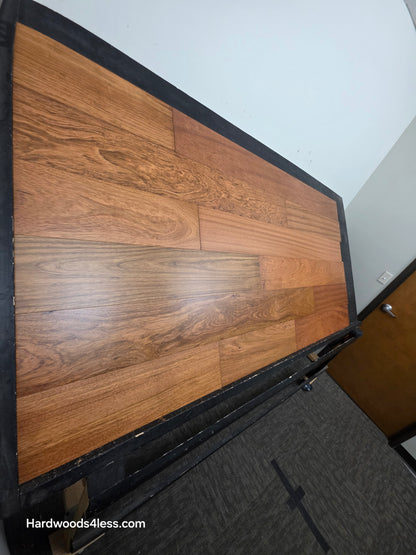 7" x 9/16" Engineered Brazilian Cherry Hardwood Flooring. shown on a black shooting table. Shot from steep left. 