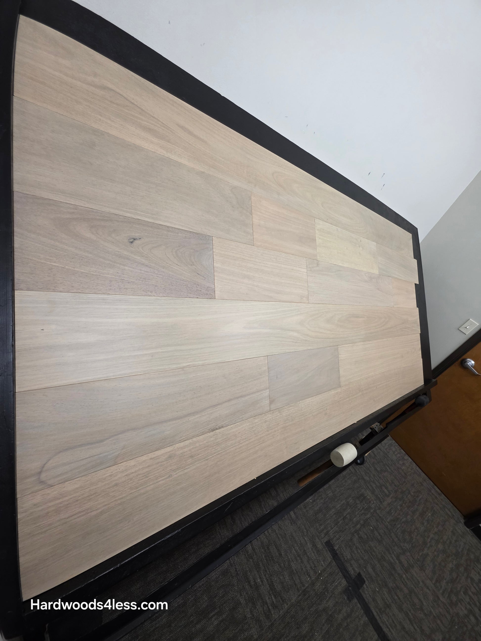 7" x 9/16" Engineered Brazilian Oak Mist Hardwood Flooring. shown on a black shooting table. Shot from steep left. 