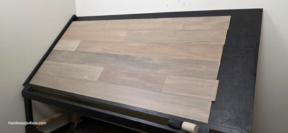 7" x 9/16" Engineered Brazilian Oak Pyrite Hardwood Flooring. Shown on a black shooting table. Shot from wide right.