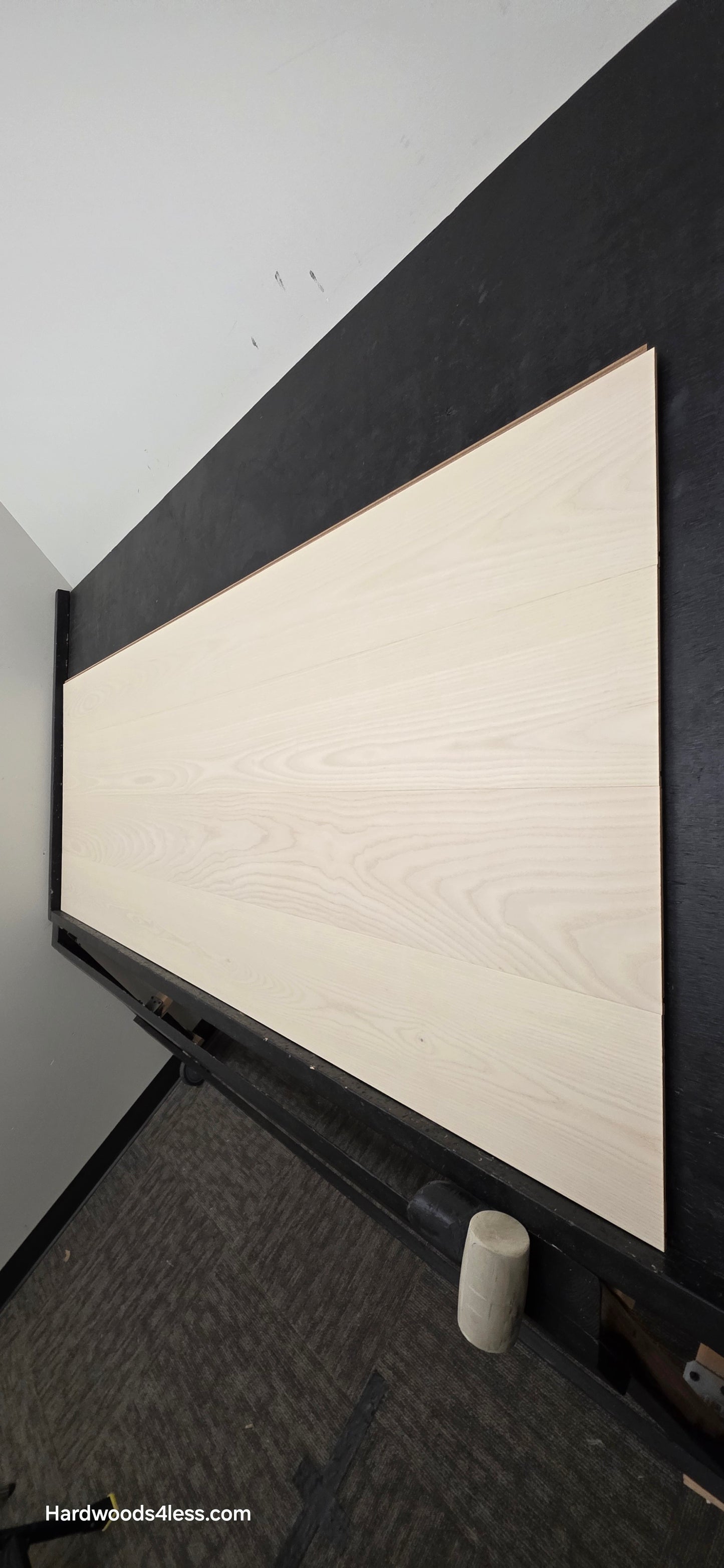 8.11" x 7/16" Modernized Engineered Ash Corbusier Hardened Hardwood Flooring. Shown on a black shooting table. Shot from steep right.