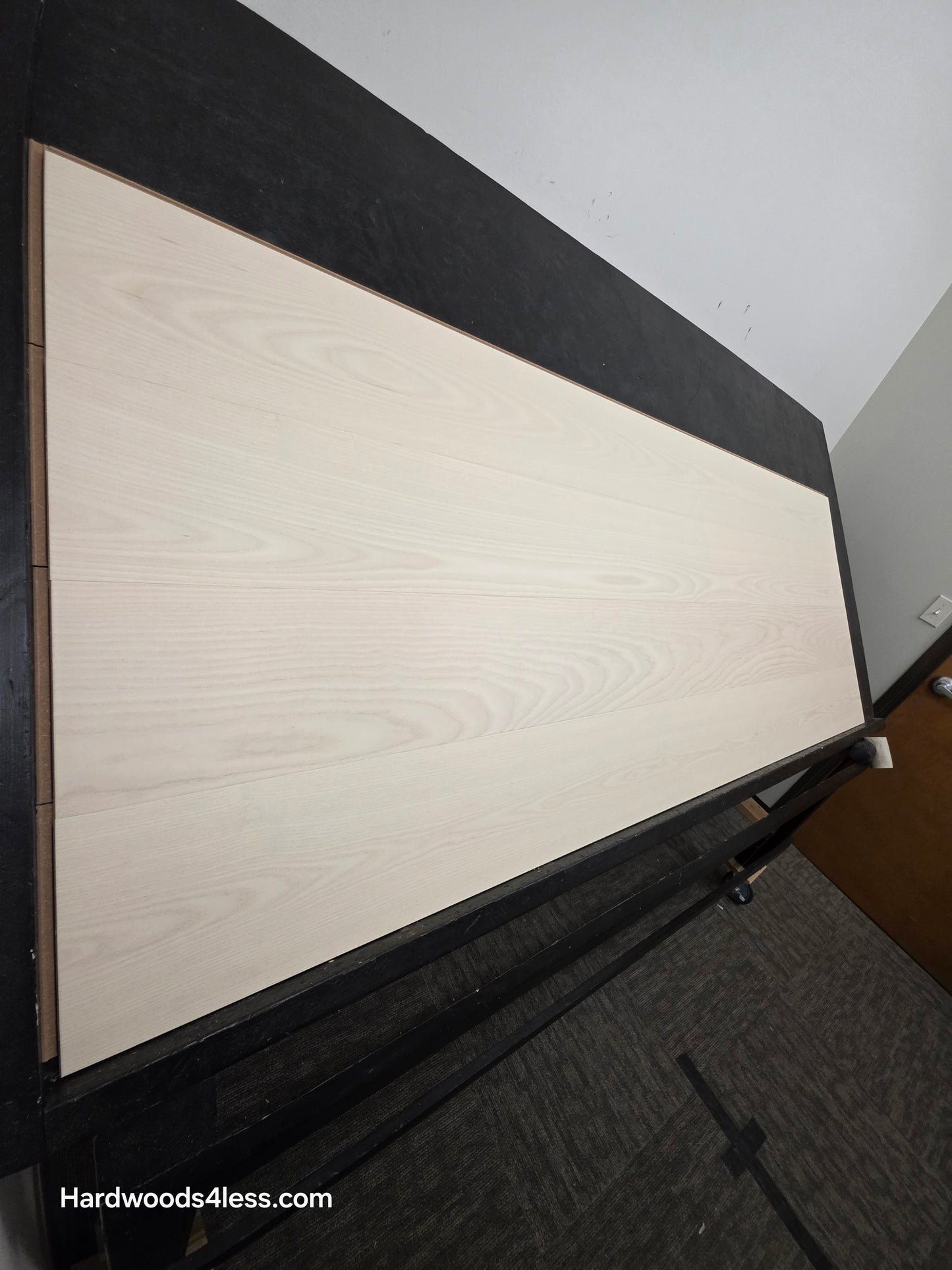 8.11" x 7/16" Modernized Engineered Ash Corbusier Hardened Hardwood Flooring. Shown on a black shooting table. Shot from steep left.