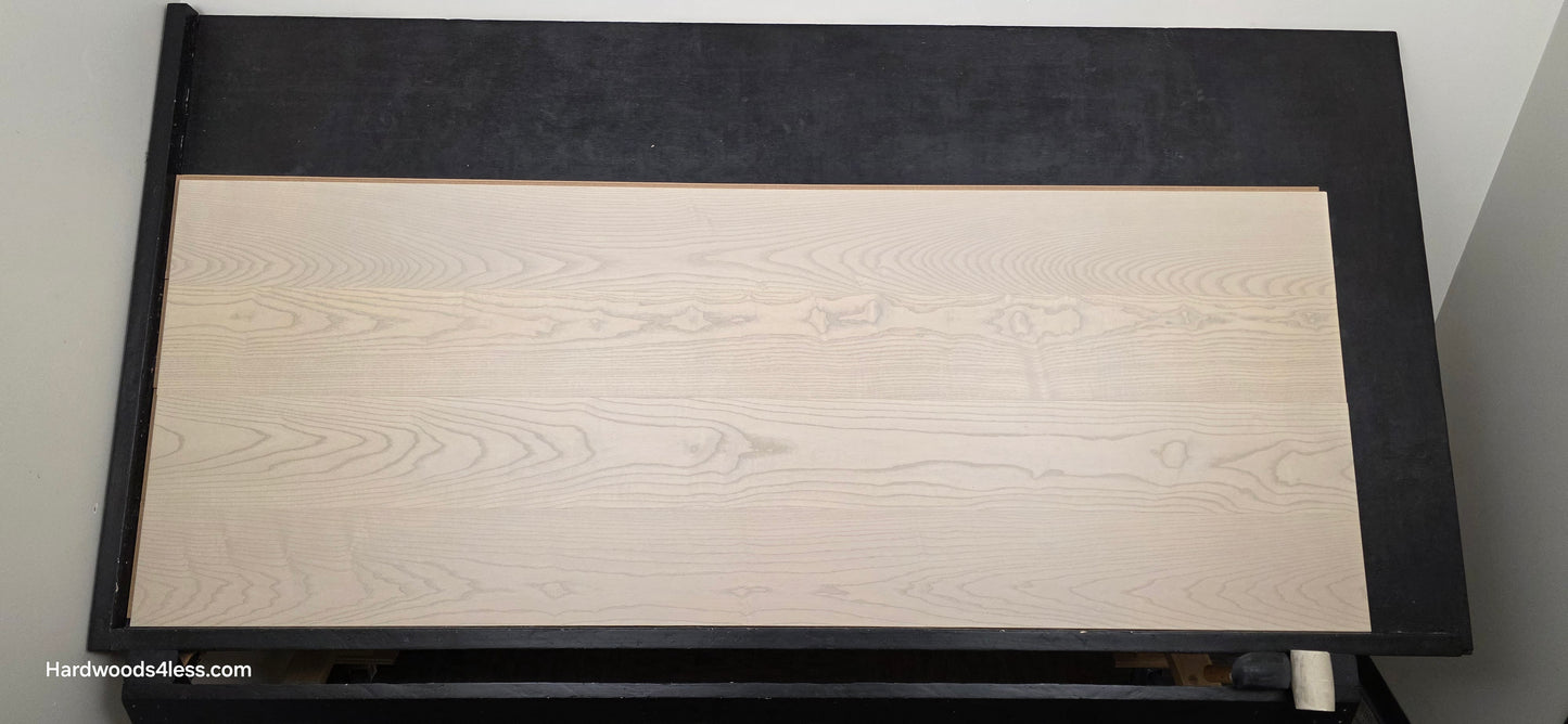 8.11" x 7/16" Modernized Engineered Ash Foster Hardened Hardwood Flooring. Shown on a black shooting table. Shot from center.